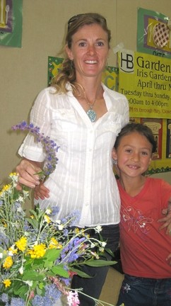 PAGING MRS. GREEN THUMB :  Penny Nyunt posed with her two favorite flowers: wooly blue curls and Lilly (her daughter).